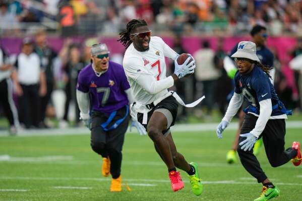AFC wide receiver Brian Thomas Jr. (7), of the Jacksonville Jaguars, runs away from NFC return specialist KaVontae Turpin, of the Dallas Cowboys, right, during the flag football event at the NFL Pro Bowl, Sunday, Feb. 2, 2025, in Orlando. (AP Photo/Chris O'Meara, File)