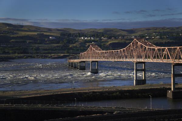 Water from the Columbia River churns below The Dalles bridge near The Dalles Dam, crossing the Washington and Oregon state line, on Sunday, June 19, 2022. The river is threatened by industrialization, climate change and pollution. (AP Photo/Jessie Wardarski)