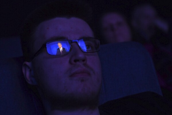 FILE - Russian President Vladimir Putin is reflected in glasses of a man as he watches a broadcast of Putin's state-of-the-nation address, in a cinema theatre in St. Petersburg, Russia, Thursday, Feb. 29, 2024. (AP Photo, File)