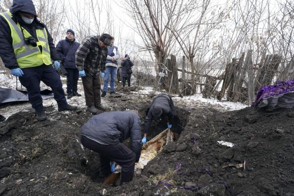 EDS NOTE: GRAPHIC CONTENT - An excavator exhumes the grave of Svitlana Shabanova, who was killed by Russian forces during evacuation on April 14, 2022 and buried at the territory of a hospital in the liberated town of Borova, Kharkiv region, Ukraine, on Wednesday, Feb. 1, 2023. The police and the war crimes prosecutor's office conducted an exhumation of local residents who were killed by Russian soldiers during their evacuation by two minivans on April 14, 2022.(AP Photo/Andrii Marienko)