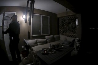 FILE - In this image taken from body camera video provided by the Farmington Police Department, a police officer knocks on the door of the wrong address in response to a domestic violence call, in Farmington, N.M., late April 5, 2023. Moments later, the homeowner was fatally shot by police after appearing at the door armed with a handgun. (Farmington Police Department via AP, File)