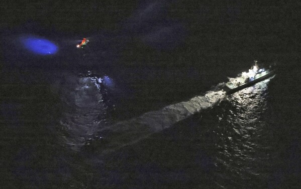 Japan's Coast Guard and helicopters conduct search and rescue operations around the site of a US military Osprey plane believed to have crashed in the sea off Yakushima Island, Kagoshima Prefecture, southern Japan, Wednesday, Nov. 29, 2023.  A US military Osprey plane carrying eight people crashed in southern Japan on Wednesday and found one person and debris in the sea, officials said.  (Kyoto News via AP)