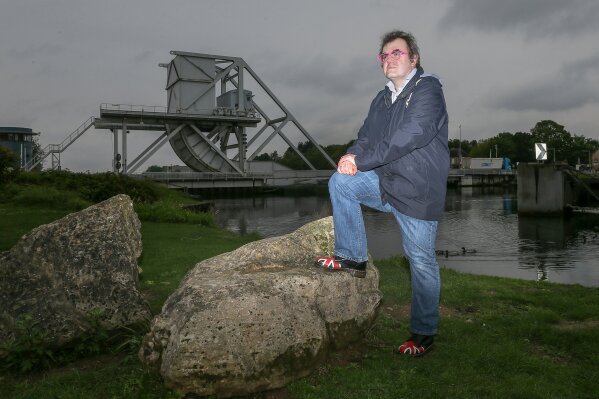 In this photo taken on Tuesday May 5, 2020. Mayeul Mace, 43, a history and geography teacher, poses at Pagasus bridge near Ranville, Normandy. Writing to World War II veterans brought home to the teens that they are living through a unique moment in time that will be remembered by future generations, said Mayeul Mace, a history teacher at Saint-Louis Middle School in Cabourg. (AP Photo/David Vincent)