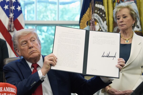 President Donald Trump holds a signed an executive order relating to school discipline policies as Education Secretary Linda McMahon listens in the Oval Office of the White House, April 23, 2025, in Washington. (AP Photo/Alex Brandon, file)