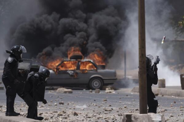 A riot police officer shots tear gas at demonstrators during a protest at the Cheikh Anta Diop University campus in Dakar, Senegal, Thursday, June 1, 2023. Senegal opposition leader Ousmane Sonko was convicted Thursday of corrupting youth but acquitted on charges of raping a woman who worked at a massage parlor and making death threats against her. (AP Photo/Leo Correa)