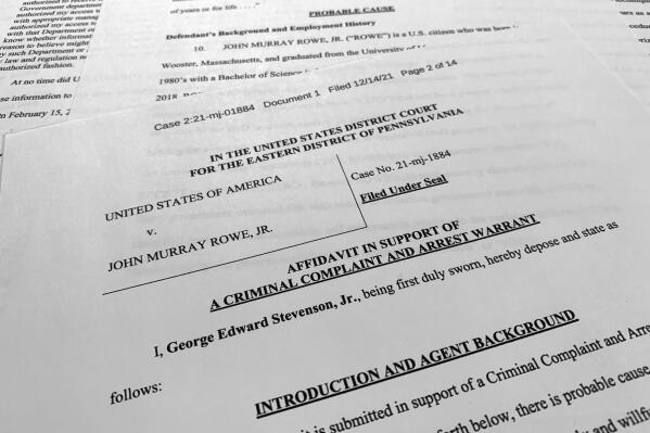 The affidavit, criminal complaint and arrest warrant for John Murray Rowe Jr., is photographed on Dec. 16, 2021. The Justice Department says the engineer who worked for decades as a federal defense contractor has been arrested on charges of trying to pass classified information to someone he thought was a Russian agents but who was actually an undercover FBI employee. (AP Photo/Jon Elswick