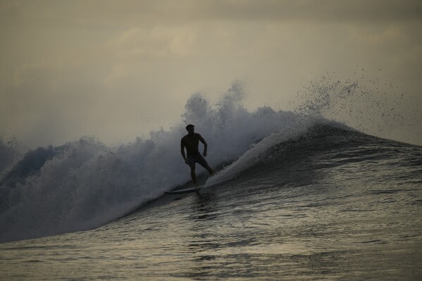 Tahitian-born surfer Kauli Vaast rides a wave in Teahupo'o, Tahiti, French Polynesia, Sunday, Jan. 13, 2024. (AP Photo/Daniel Cole)