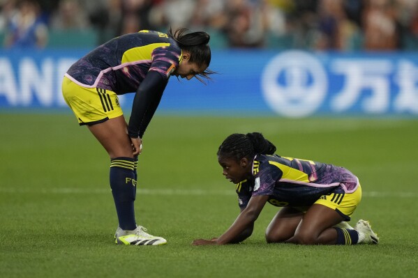 Colombia's Linda Caicedo, right, is injured as Colombia's Manuela Vanegas checks on her during the Women's World Cup Group H soccer match between Germany and Colombia at the Sydney Football Stadium in Sydney, Australia, Sunday, July 30, 2023. (AP Photo/Rick Rycroft)