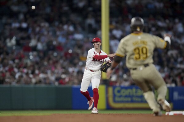 Los Angeles Angels shortstop Zach Neto throws to first for the out on San Diego Padres' Jake Cronenworth to end the top of the sixth inning, as Donovan Solano (39) runs toward second during a baseball game in Anaheim, Calif., Tuesday, June 4, 2024. (AP Photo/Eric Thayer)