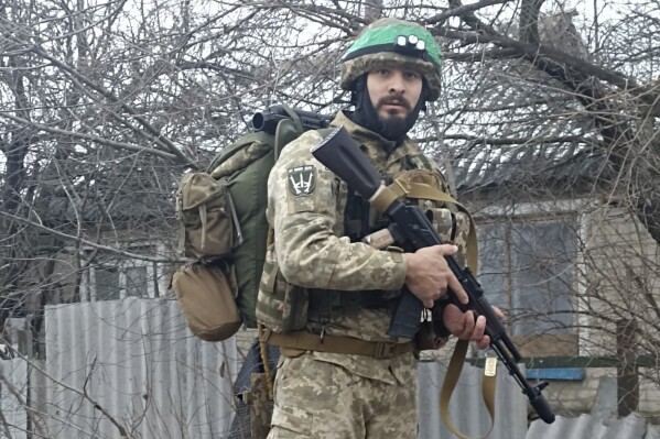 This 2023 photo provided by a 32-year-old professional soldier from Medellín, Colombia who goes by the call sign Checho shows him in his combat gear in Donbas, eastern Ukraine. Checho says he was struck by fire from a drone during a rescue operation to save a wounded colleague on the front line after three days of heavy fighting with Russian forces. At the hospital in the Kyiv region, Checho found himself with more than fifty other Colombians, most with light injuries sustained while fighting Russian occupation forces in eastern Ukraine’s Donetsk region. They are among hundreds of Colombian veterans who have made the journey to Ukraine to help its forces fight the Russians. (Courtesy of Checho via AP)