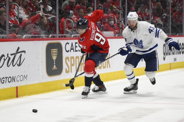 Toronto Maple Leafs left wing Kyle Clifford (43) and Washington Capitals center Evgeny Kuznetsov (92) get their sticks entangled during the second period of an NHL hockey game, Sunday, April 24, 2022, in Washington. (AP Photo/Nick Wass)