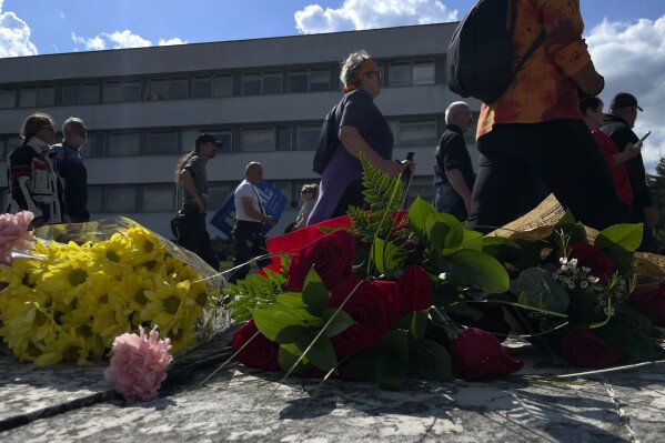 People gather and bring flowers outside the F. D. Roosevelt University Hospital, where Slovak Prime Minister Robert Fico, who was shot and injured, is being treated, in Banska Bystrica, central Slovakia, Sunday, May 19, 2024. Slovakia's populist prime minister, Robert Fico, remained in serious condition on Sunday but has been given a positive prognosis four days after he was shot multiple times in an assassination attempt that has sent shockwaves across the deeply polarized European Union nation, the defense minister Rober Kalinak said. (AP Photo/Lefteris Pitarakis)