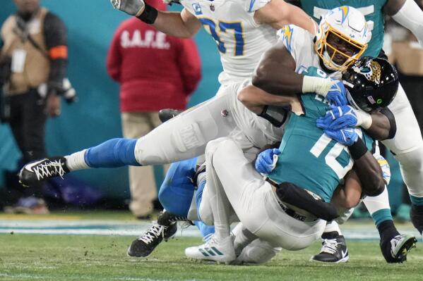 Los Angeles Chargers defensive tackle Sebastian Joseph-Day (69) sacks Jacksonville Jaguars quarterback Trevor Lawrence (16) during the first of an NFL wild-card football game, Saturday, Jan. 14, 2023, in Jacksonville, Fla. (AP Photo/Chris O'Meara)