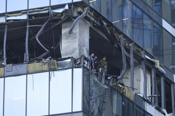 Investigators examine a damaged skyscraper in the 