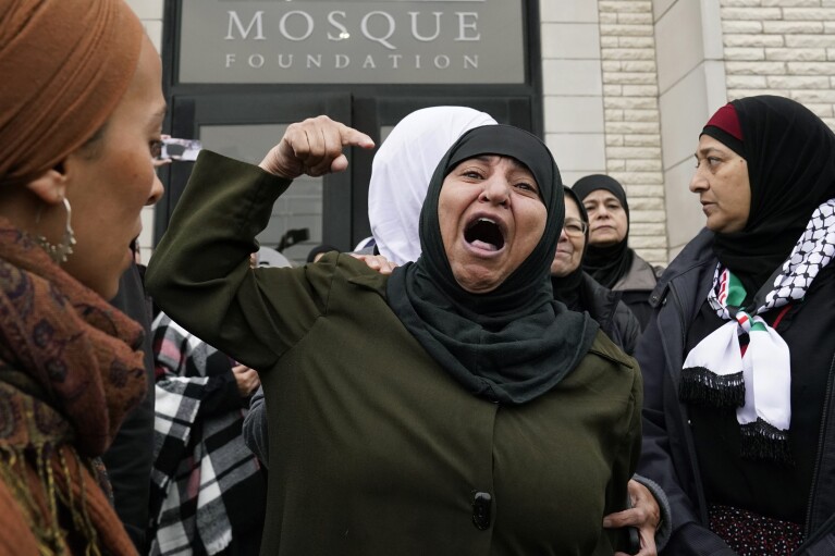 A Muslim community member shouts into the crowd for Wadea Al Fayoume at Mosque Foundation in Bridgeview, Ill., Monday, Oct. 16, 2023. An Illinois landlord accused of fatally stabbing the 6-year-old Muslim boy and seriously wounding his mother was charged with a hate crime after police and relatives said he singled out the victims because of their faith and as a response to the war between Israel and Hamas. (AP Photo/Nam Y. Huh)