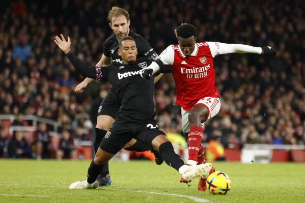 Arsenal's Eddie Nketiah, right, duels for the ball with West Ham's Thilo Kehrer during the English Premier League soccer match between Arsenal and West Ham United at Emirates stadium in London, Monday, Dec. 26, 2022. (AP Photo/David Cliff)