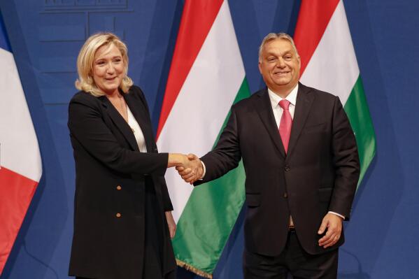 French far-right leader Marine le Pen, left, shakes hands with Hungarian Prime Minister Viktor Orban after a joint press conference in Budapest, Hungary, Tuesday, Oct. 26, 2021. (AP Photo/Laszlo Balogh)