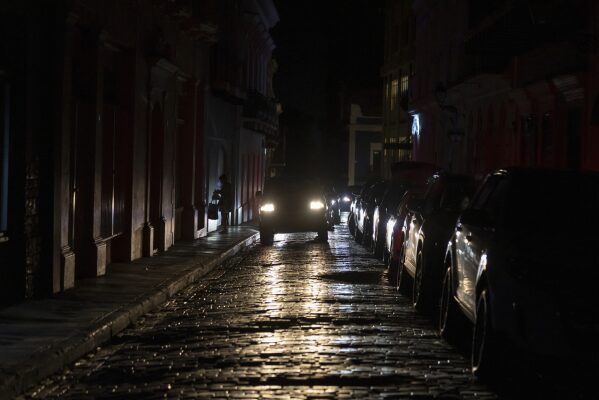 Headlights illuminate cobblestone streets in Old San Juan, Puerto Rico, during an island-wide blackout, Wednesday, April 16, 2025. (AP Photo/Alejandro Granadillo)