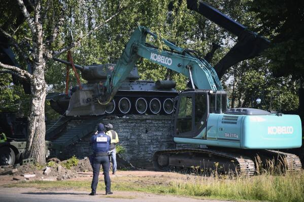 FILE - Workers remove a Soviet T-34 tank installed as a monument in Narva, Estonia, Aug. 16, 2022. Russia's invasion of Ukraine has led to a renewed push to topple the last remaining monuments to the Soviet army that remained in Europe. At the end of the communist era, when Latvia, Lithuania and Estonia regained their independence from the Soviet Union, those countries began renaming streets and toppling statues of Lenin and other communist figures. But many memorials to the Red Army remained. (AP Photo/Sergei Stepanov, File)
