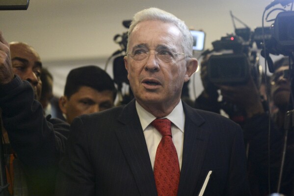 FILE - Former President Alvaro Uribe arrives for a press conference at the Democratic Center party headquarters, in Bogota, Colombia, June 29, 2022. On Friday, May 24, 2024, Uribe was formally charged with witness tampering and bribery for his efforts to discredit a political opponent who was digging into his family ties to right-wing paramilitary groups. (AP Photo/Lina Gasca, File)