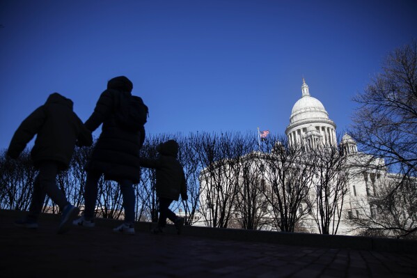 FILE - Pedestrians walk past the Rhode Island Statehouse, March 1, 2020, in Providence, R.I. The Rhode Island Senate debated a bill Tuesday, March 19, 2024, that would require all firearms, when not in use by the owner or other authorized user, to be stored in a locked container or equipped with a tamper-resistant mechanical lock or other safety device. (AP Photo/David Goldman, File)
