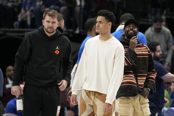 Dallas Mavericks' Luka Doncic, left, Josh Green, center, and Kyrie Irving, right, stand on the court during a timeout in the second half of an NBA basketball game against the Chicago Bulls, Friday, April 7, 2023, in Dallas. (AP Photo/Tony Gutierrez)