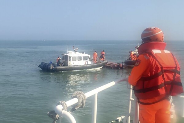 In this handout photograph provided by Taiwan Coast Guard Administration, Taiwanese coast guards inspect a vessel that capsized during a chase off the coast of Kinmen archipelago in Taiwan, Wednesday, Feb. 14, 2024. The unnamed vessel had been sailing about one nautical mile off the coast of an islet of Kinmen island and was trespassing, said Taiwan鈥檚 Coast Guard Administration. Four fishermen fell into the water and two survived and are in 鈥済ood shape,鈥� while resuscitation efforts on the other two failed, the vice director of the Coast Guard in Kinmen, Chen Jien-wen, told a local TV channel. (Taiwan Coast Guard Administration via 番茄直播)