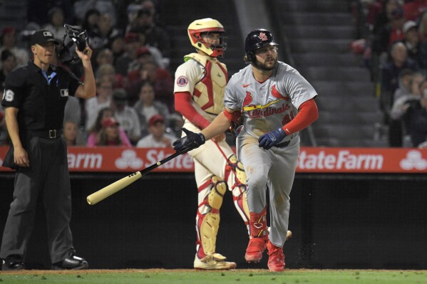 St. Louis Cardinals' Alec Burleson, right, heads to first after hitting a two-run home run as Los Angeles Angels catcher Logan O'Hoppe, center, and home plate umpire Chris Segal watch during the seventh inning of a baseball game Tuesday, May 14, 2024, in Anaheim, Calif. (AP Photo/Mark J. Terrill)