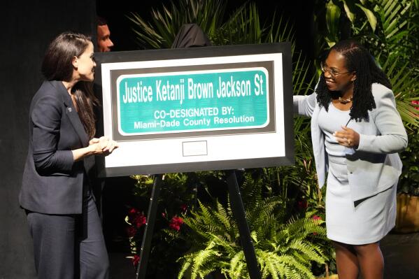 CORRECTS FIRST NAME TO KETANJI U.S. Supreme Court Justice Ketanji Brown Jackson looks at a street sign named in her honor, Monday, March 6, 2023, in Cutler Bay, Fla. To the left is Miami-Dade Commissioner Danielle Cohen Higgins who sponsored the event. The street is located in south Dade County where Justice Brown Jackson grew up. (AP Photo/Marta Lavandier)