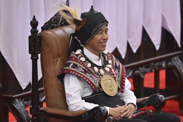 Indonesian President Joko Widodo, wearing traditional attire from Tanimbar Islands of Maluku province, takes his seat before delivering his State of the Nation Address ahead of the country's Independence Day, at the parliament building in Jakarta, Indonesia, Wednesday, Aug. 16, 2023. (Adek Berry/Pool Photo via AP)