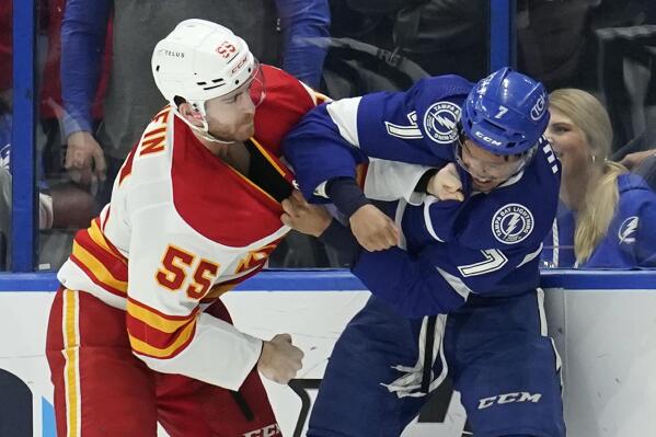 Calgary Flames defenseman Noah Hanifin (55) and Tampa Bay Lightning right wing Mathieu Joseph (7) fight during the first period of an NHL hockey game Thursday, Jan. 6, 2022, in Tampa, Fla. (AP Photo/Chris O'Meara)