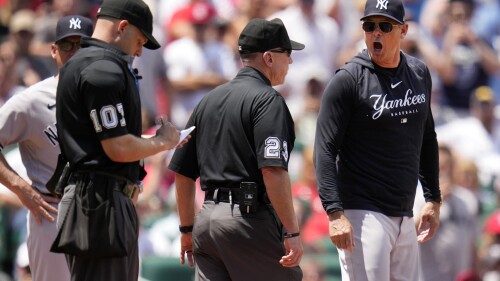 New York Yankees manager Aaron Boone, right, yells after being ejected by home plate umpire Dan Merzel, left, as umpire crew chiefs Lance Barksdale (23) stands between the two during the third inning of a baseball game against the St. Louis Cardinals Sunday, July 2, 2023, in St. Louis. (AP Photo/Jeff Roberson)