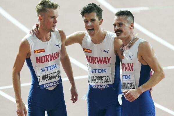 FILE - From left, brothers Filip Ingebrigtsen, Jakob Ingebrigtsen, and Henrik Ingebrigtsen, of Norway, react after competing in the men's 5000 meter final at the World Athletics Championships in Doha, Qatar, on Sept. 30, 2019. Father of Ingebrigtsen brothers is charged with abuse of “one of his minor children,” lawyer says. (AP Photo/Nick Didlick, File)