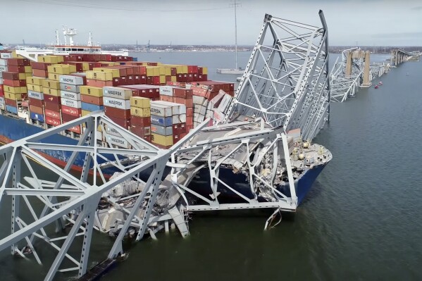 In this image taken from video released by the National Transportation and Safety Board, the cargo ship Dali is stuck under part of the structure of the Francis Scott Key Bridge after the ship hit the bridge, Tuesday, March 26, 2024, in Baltimore. (NTSB via AP)