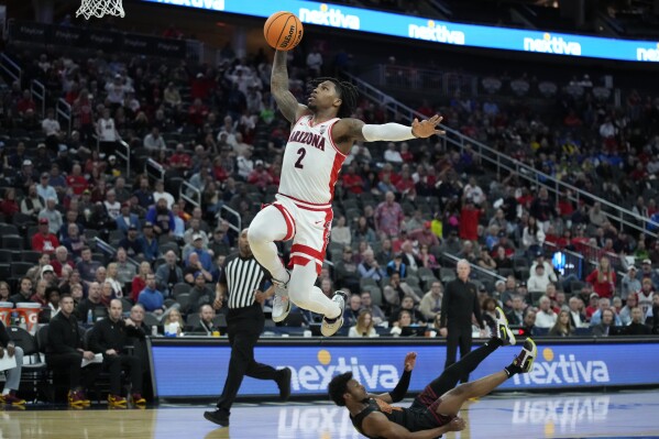 Arizona guard Caleb Love (2) shoots over Southern California guard Bronny James (6) during the first half of an NCAA college basketball game in the quarterfinal round of the Pac-12 tournament Thursday, March 14, 2024, in Las Vegas. (AP Photo/John Locher)