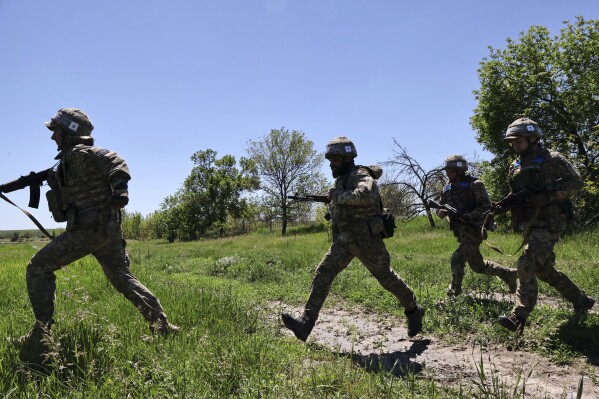 In this photo provided by Ukraine's 65th Mechanized Brigade press service, Ukrainian servicemen practice at the military training ground in the Zaporizhzhia region, Ukraine, Thursday, May 22, 2025, (Andriy Andriyenko/Ukraine's 65th Mechanized Brigade via AP)