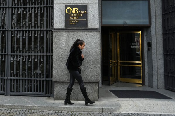 FILE - A woman walks outside the czech central bank in Prague, Czech Republic, on Nov. 2, 2023. On Thursday Feb. 8, 2024, the Czech Republic's central bank cut its key interest rate for the second straight time in efforts to help the country's struggling economy. The cut by a half percentage point brought the interest rate down to 6.25%. (AP Photo/Petr David Josek/File)