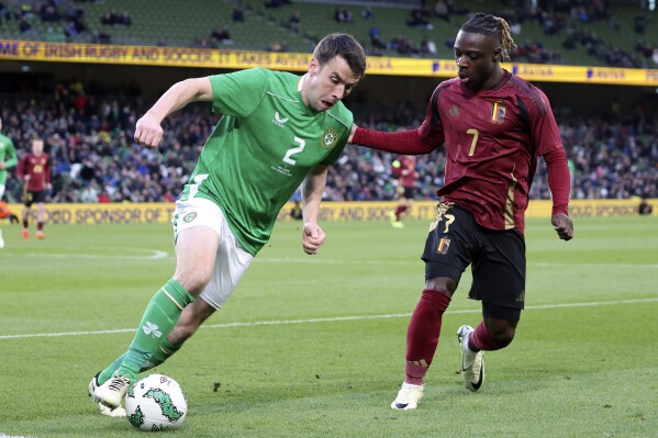 Ireland's Seamus Coleman , left, and Belgium's Jeremy Doku challenge for the ball during the international friendly soccer match between Ireland and Belgium at the Aviva Stadium in Dublin, Ireland, Saturday, March 23, 2024. (AP Photo/Peter Morrison)