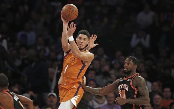 Phoenix Suns' Devin Booker (1) looks to pass over New York Knicks' Julius Randle (30) during the first half of an NBA basketball game Friday, Nov. 26, 2021, in New York. AP Photo/John Munson)