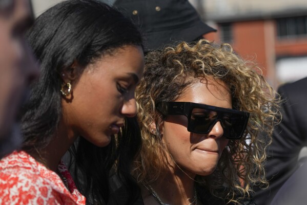 Raquel Smith, right, widow of former NFL New Orleans Saints star Will Smith, and their daughter Lisa Smith leave Orleans Parish Criminal District Court in New Orleans, Wednesday, Sept. 20, 2023, after a hearing regarding the retrial for Cardell Hayes, who fatally shot Smith and wounded Raquel, in a confrontation after a 2016 traffic crash.. (AP Photo/Gerald Herbert)