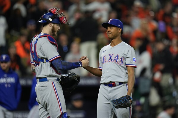 Texas Rangers relief pitcher Jose Leclerc, right, celebrates with catcher Jonah Heim after the last out of Game 2 in an American League Division Series baseball game against the Baltimore Orioles, Sunday, Oct. 8, 2023, in Baltimore. The Rangers defeated the Orioles 11-8. (AP Photo/Julio Cortez)