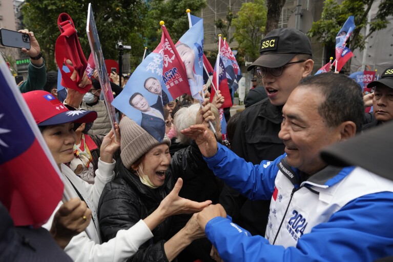 FILE - Taiwan's Nationalist Party presidential candidate Hou Yu-ih is welcomed by residents while campaigning in a neighborhood in Taipei, Taiwan, January 9, 2024.  Taiwan holds presidential and parliamentary elections on Saturday, which China has described as a choice between war and peace.  ,  Hou is a candidate from Taiwan's main opposition party, the Kuomintang, or KMT, whose government withdrew from the island after losing a civil war against the Chinese Communist Party in 1949.  (AP Photo/Ng Han Guan, File)