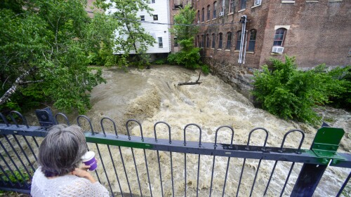 Melissa Morgan de Northfield, Massachusetts, observa el flujo de agua en Whetstone Brook en Brattleboro, Vt., el lunes 10 de julio de 2023.  (Reformador de Brattleboro vía Christopher Rader/AP)