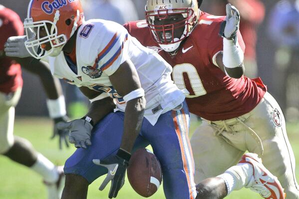 FILE - Florida receiver Percy Harvin, left, drops a second-quarter pass and he is hit by Florida State's Geno Hayes, right, during  an NCAA college football game in Tallahasse, Fla., in this Saturday, Nov. 25, 2006, file photo. Hayes, a former NFL linebacker who starred at Florida State, has died. He was 33. The Tampa Bay Buccaneers on Tuesday, April 27, 2021, confirmed his death. He had liver disease and had been in hospice care. (AP Photo/Phil Coale, File)