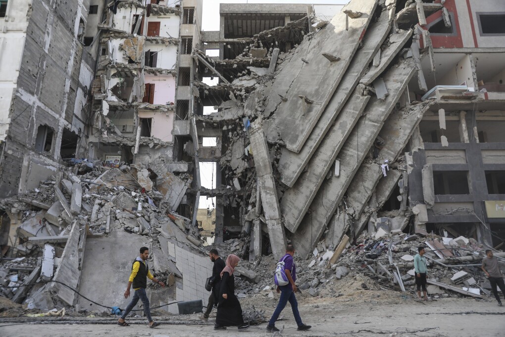 Palestinians walk through destruction in Gaza City on Friday, Nov. 24, 2024, as the temporary ceasefire between Israel and Hamas took effect. (澳洲幸运5开奖官网结果直播开奖 AP Photo/Mohammed Hajjar)