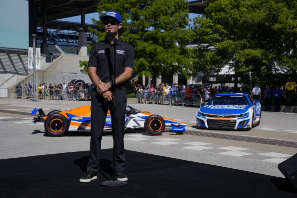 Kyle Larson talks about his attempt to drive both the IndyCar Indianapolis 500 and the Charlotte NASCAR Cup Series auto races on the same day next year after his car for the 500 was unveiled at Indianapolis Motor Speedway in Indianapolis, Sunday, Aug. 13, 2023. (AP Photo/Michael Conroy)