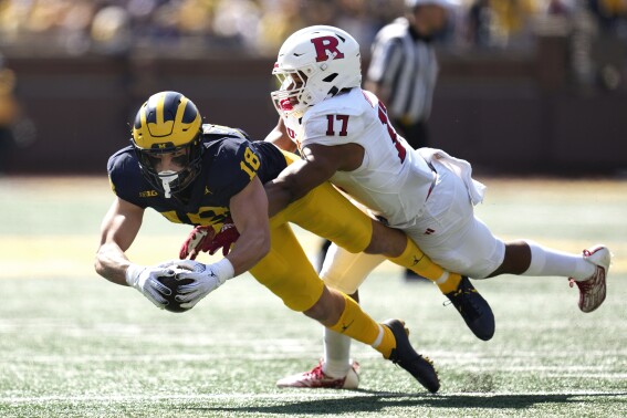 Michigan tight end Colston Loveland (18) reaches for yardage after a catch as Rutgers linebacker Deion Jennings (17) defends in the first half of an NCAA college football game in Ann Arbor, Mich., Saturday, Sept. 23, 2023. (AP Photo/Paul Sancya)