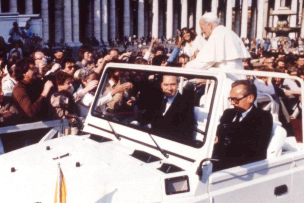 Scene in St. Peters Square on May 13. 1981, when Pope John Paul II was shot. A gun can be seen at far left above the head of a man wearing sunglasses (AP Photo)