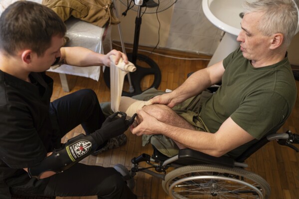 Dr. Alexis Cholas, left, bandages an amputated limb of Serhiy Hohdan, Ukrainian soldier on the well being facility's rehabilitation center in Kyiv, Ukraine, Wednesday, Nov. 8, 2023. Most of his patients are individuals of the protection force and civilians who, esteem him, get misplaced limbs. He says their shared skills helps him mercurial model a rapport alongside with his patients. (AP Photo/Evgeniy Maloletka)