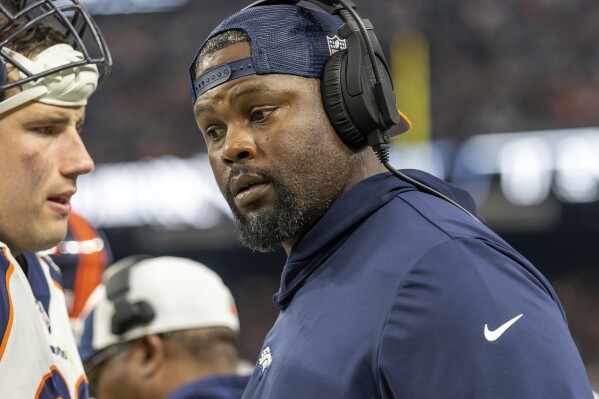 FILE - Denver Broncos defensive line coach Marcus Dixon, right, talks during an NFL football game against the Las Vegas Raiders, Jan. 7, 2024, in Las Vegas. The Minnesota Vikings have filled two coaching staff vacancies by hiring former Broncos defensive line coach Dixon and adding outside linebackers coach to Mike Pettine’s role. (AP Photo/Jeff Lewis, File)